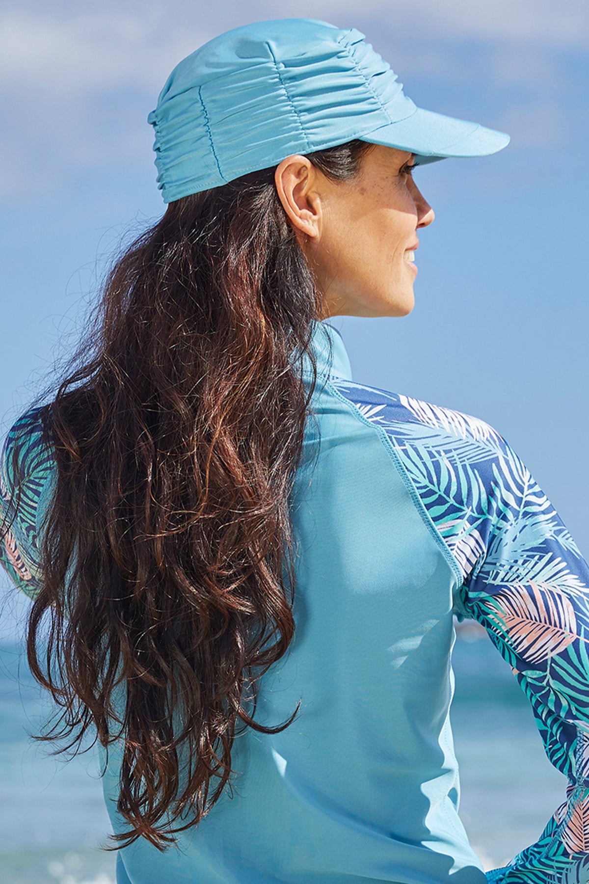 Woman wearing UV Skinz's women's swim cap in lagoon|lagoon