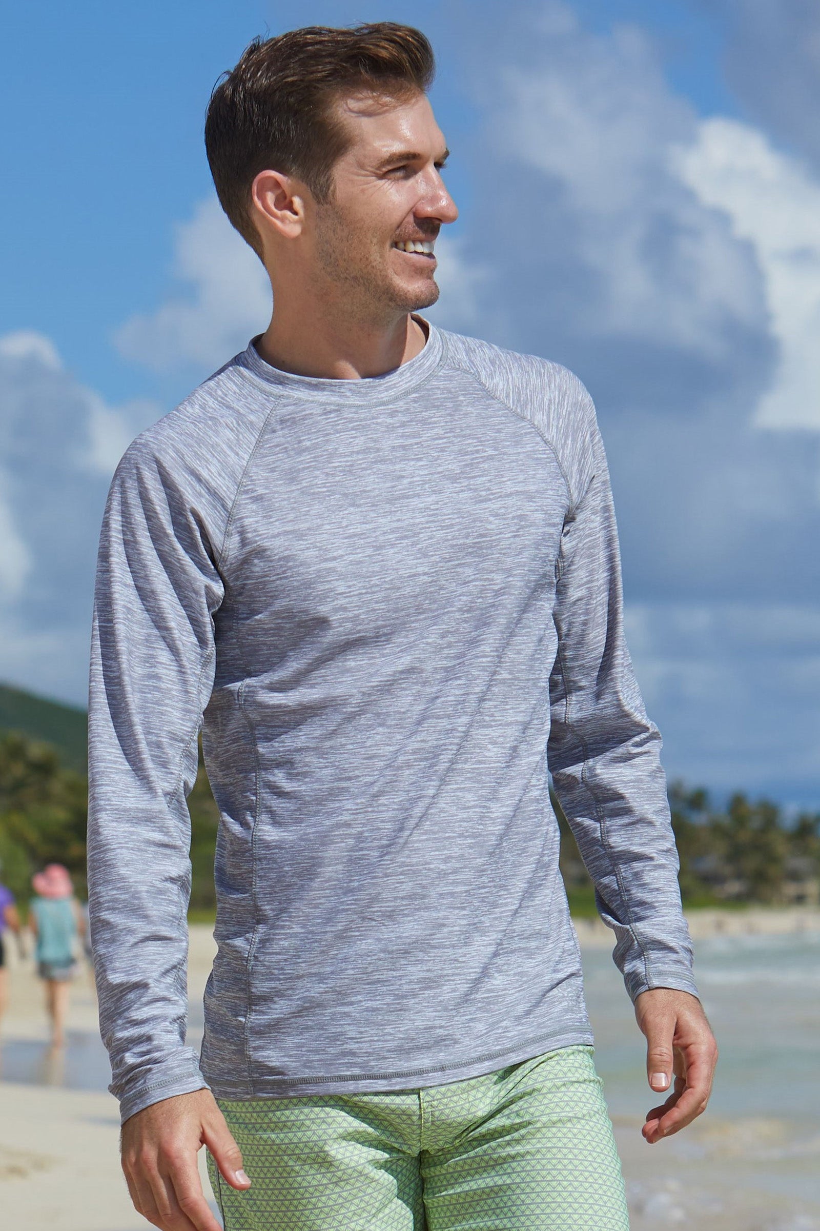 Man on the beach in UV Skinz's men's long sleeve crew swim shirt in cool grey jaspe|cool-grey-jaspe
