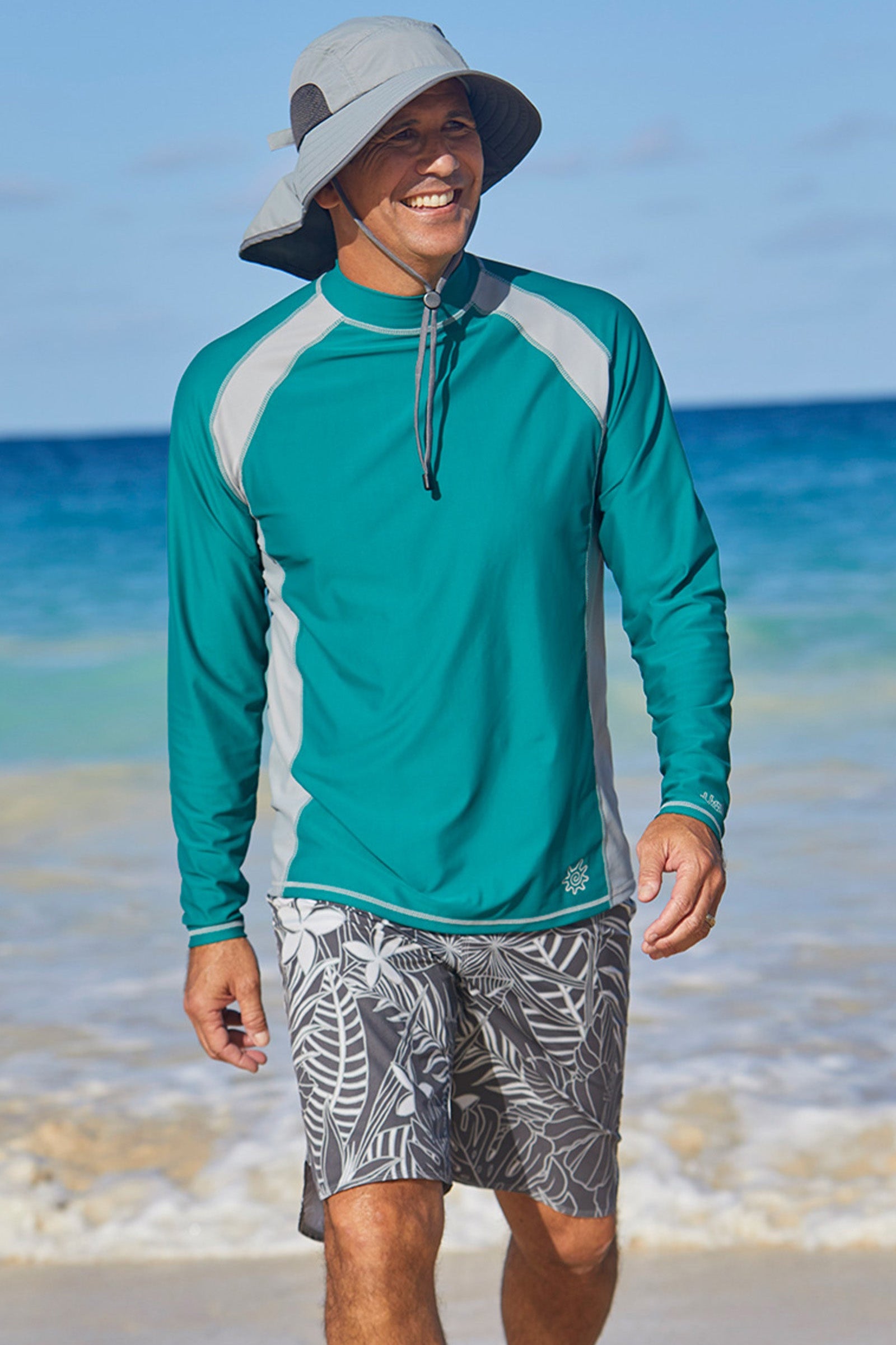 Man on the beach in UV Skinz's board shorts|charcoal-oasis