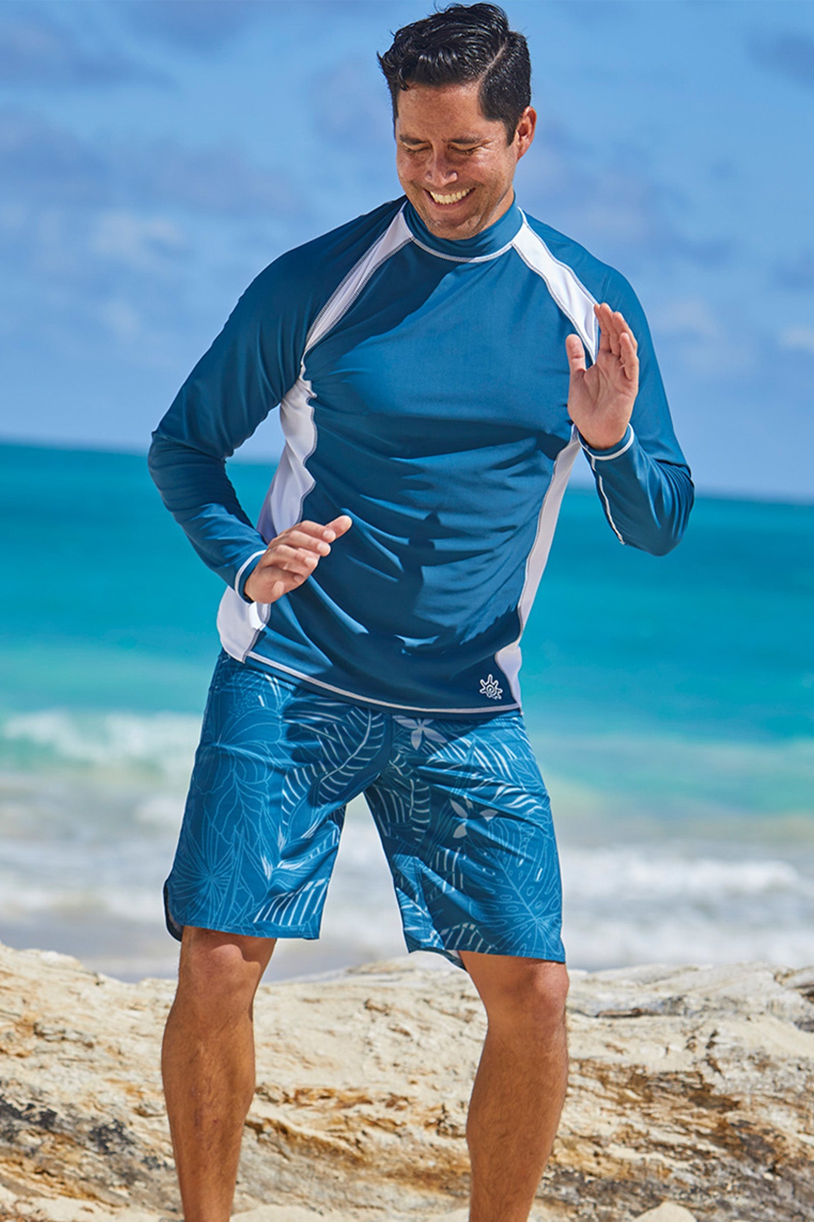 Man playing on the beach in UV Skinz's board shorts|midnight-oasis