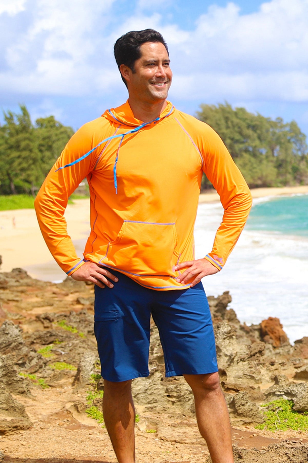 Man on the beach in UV Skinz's men's coastal board shorts in dark navy|dark-navy