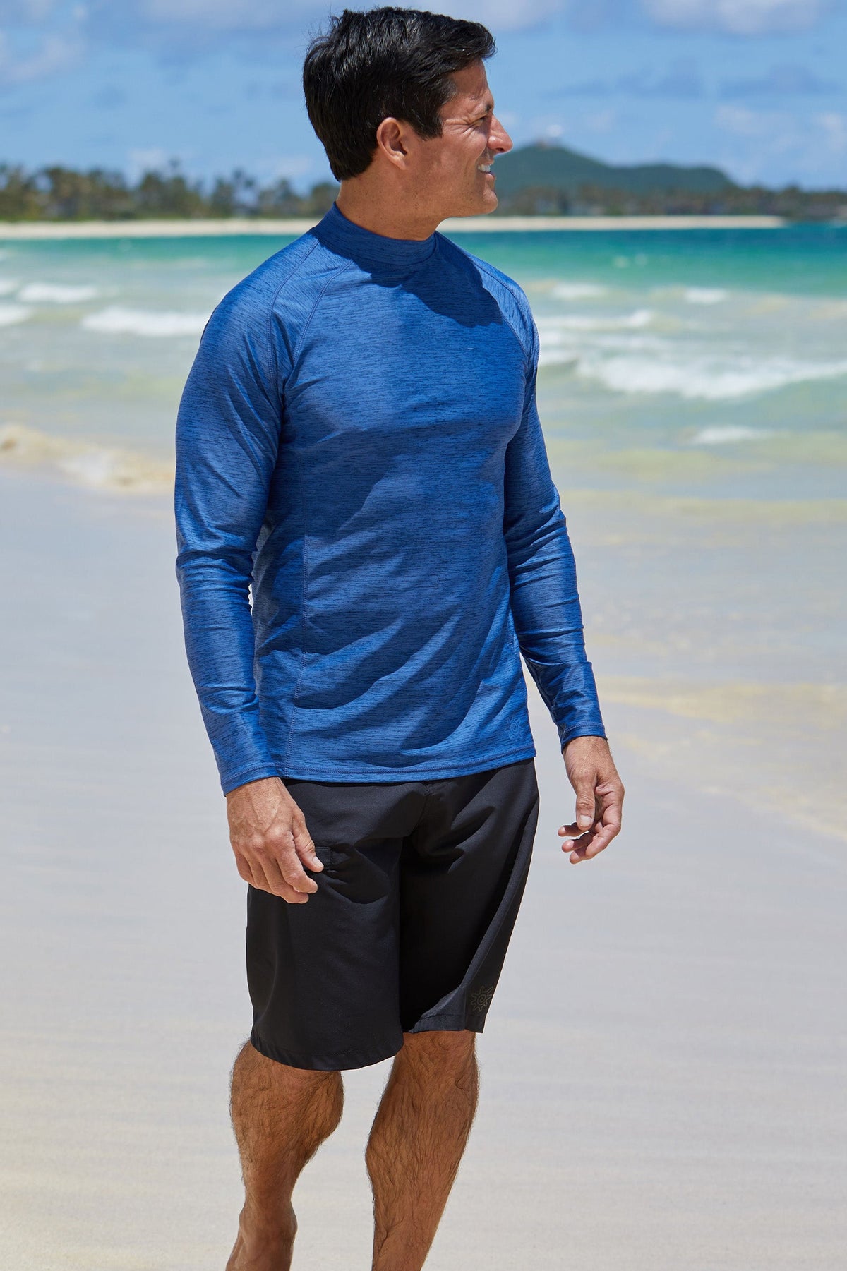 Man on the beach in UV Skinz's men's long sleeve active swim shirt