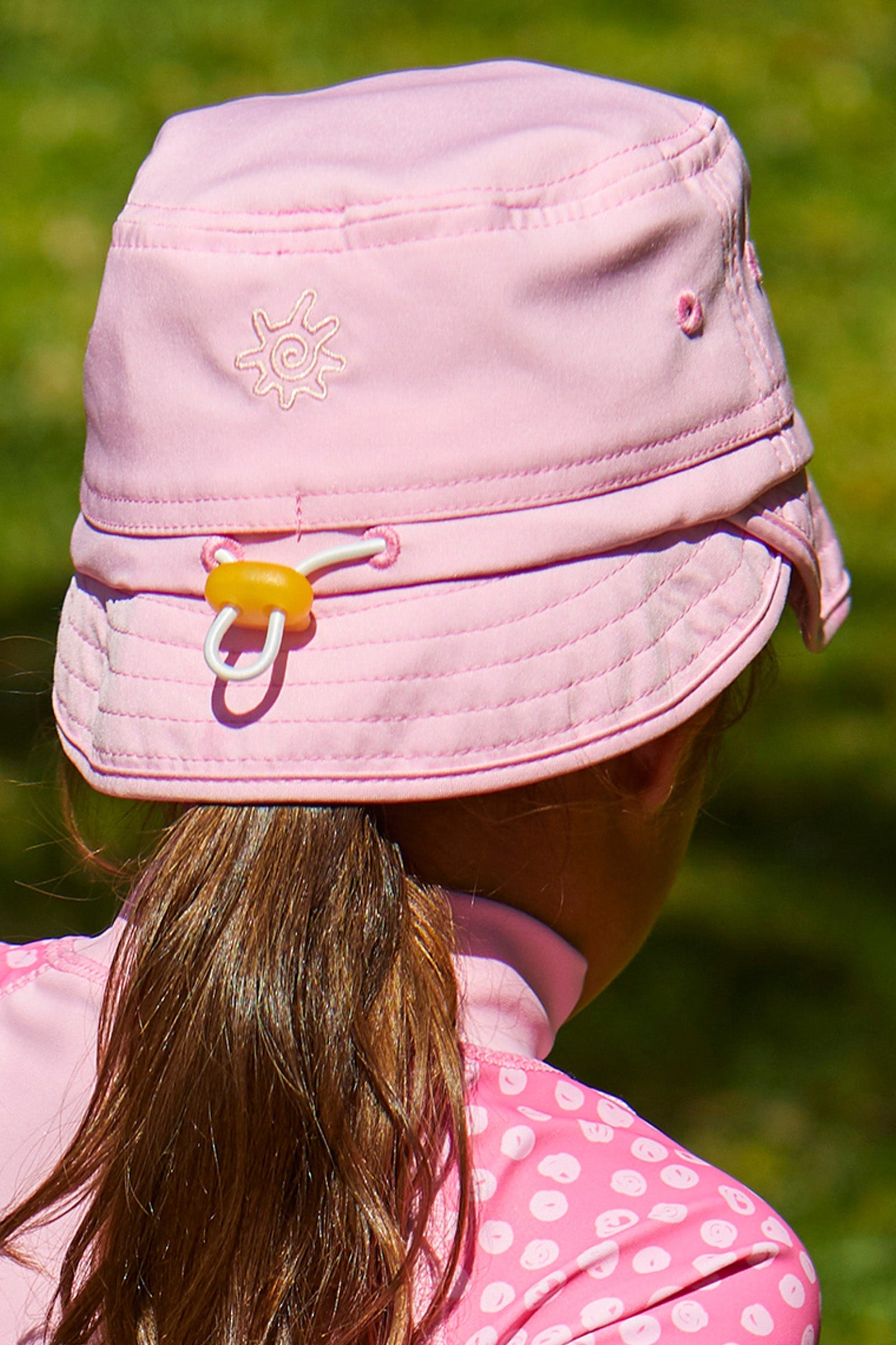 back view of the kid's adjustable flap sun hat in light pink|light-pink
