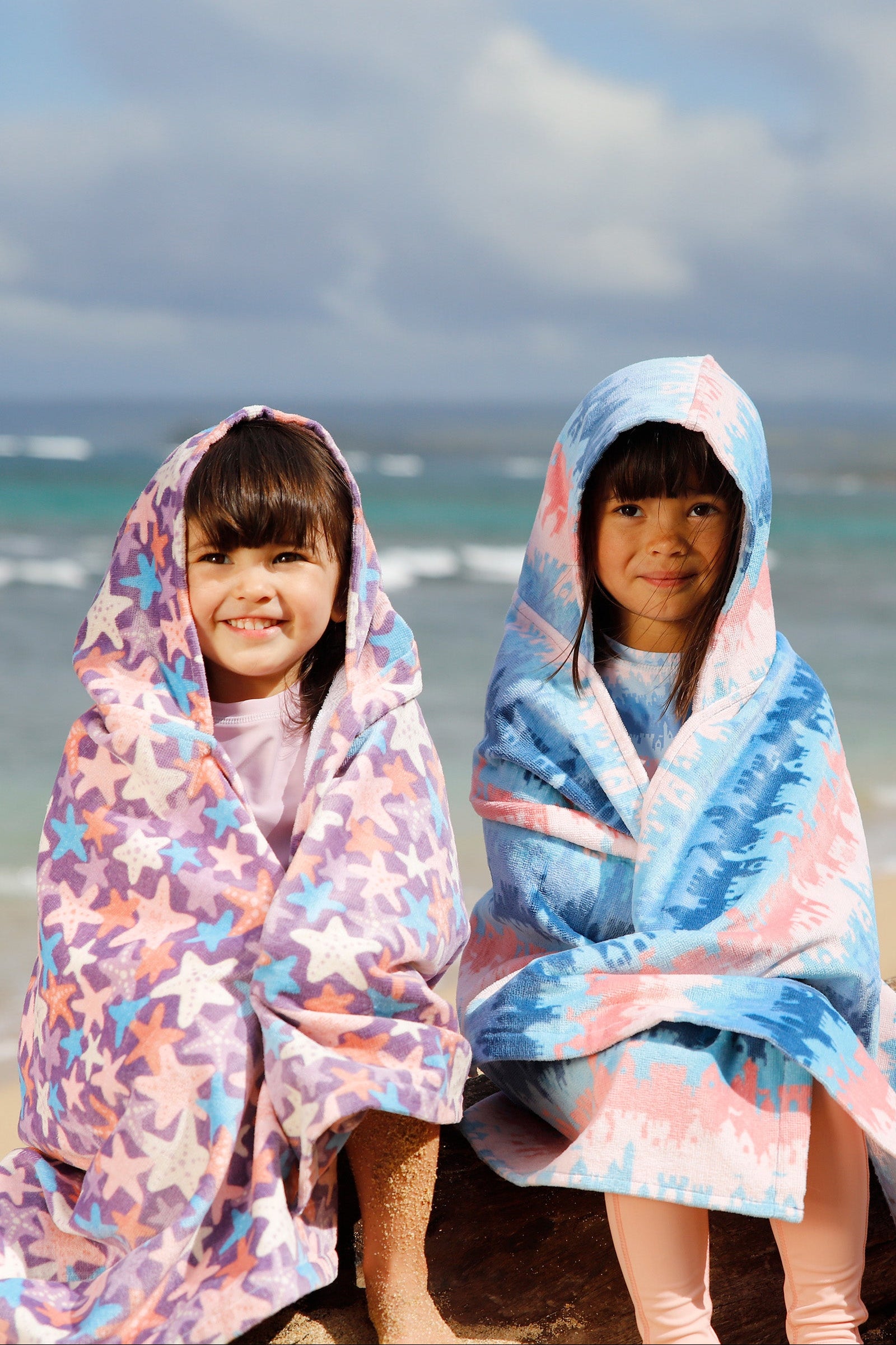 girls sitting on beach in kids hooded beach towel|sandcastle-dreams