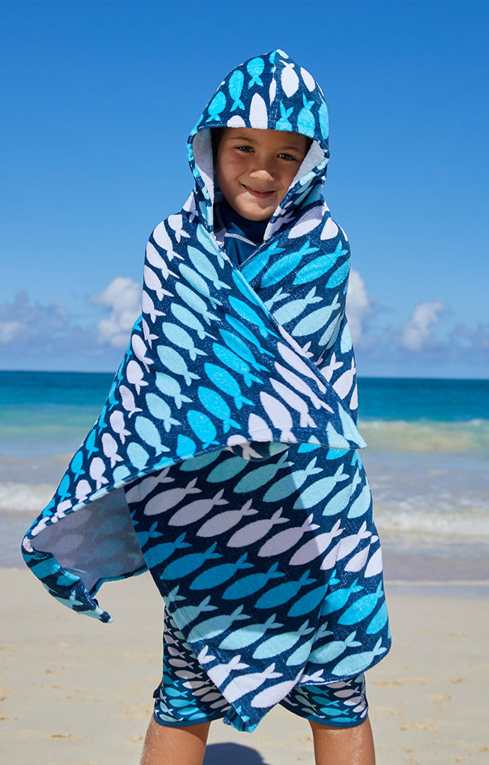Kid in UV Skinz's kid's hooded beach towel in fish trailz|fish-trailz