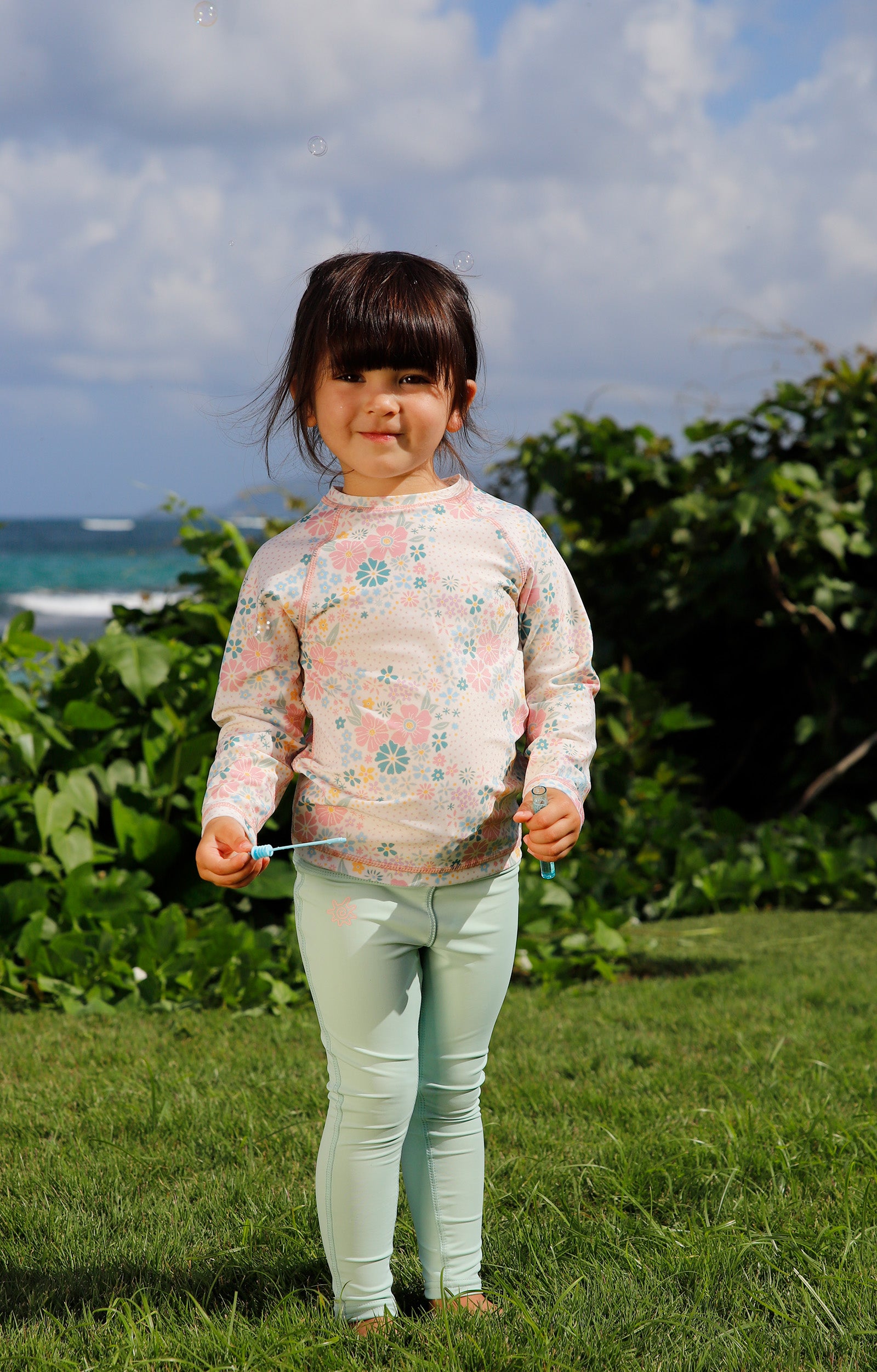girl on the grass with bubbles in kids long sleeve crew sunny swim shirt in secret garden|secret-garden
