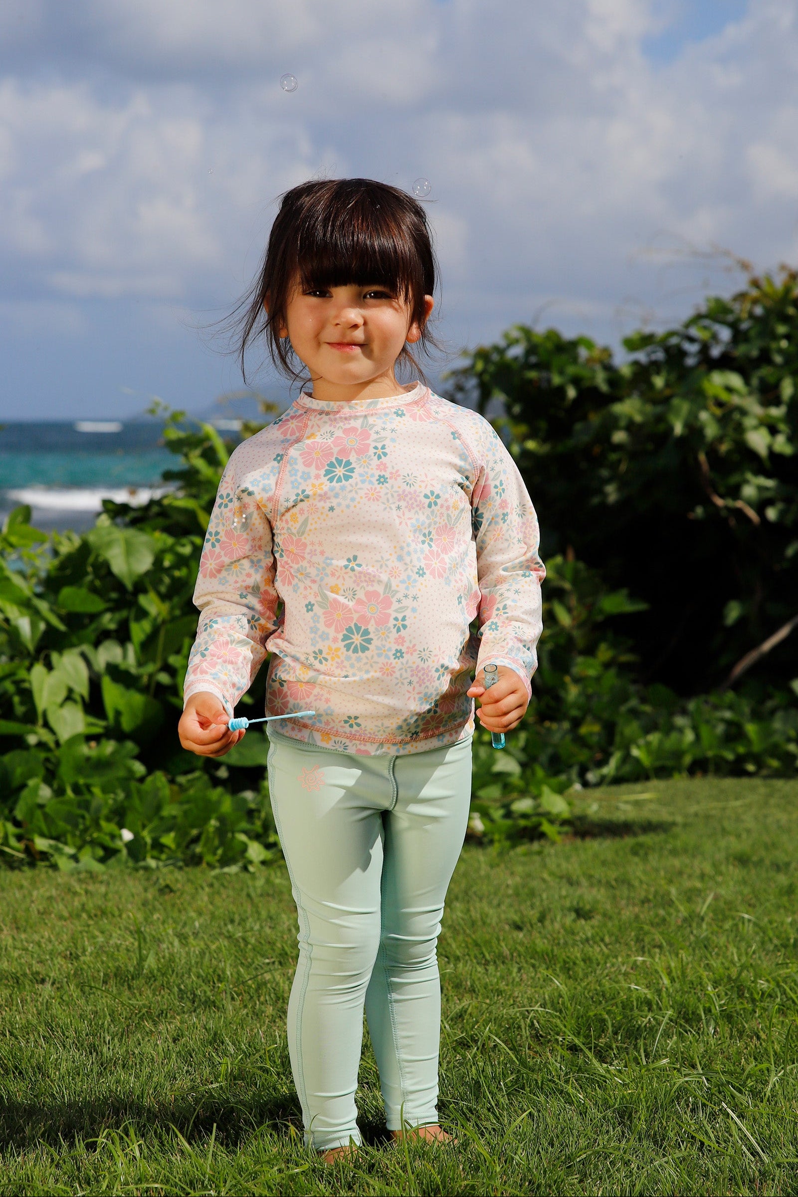 girl on the grass with bubbles in kids long sleeve crew sunny swim shirt in secret garden|secret-garden