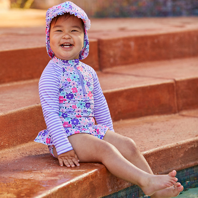 Baby girl in UV Skinz's baby girl's swim flap hat in purple poppy|purple-poppy