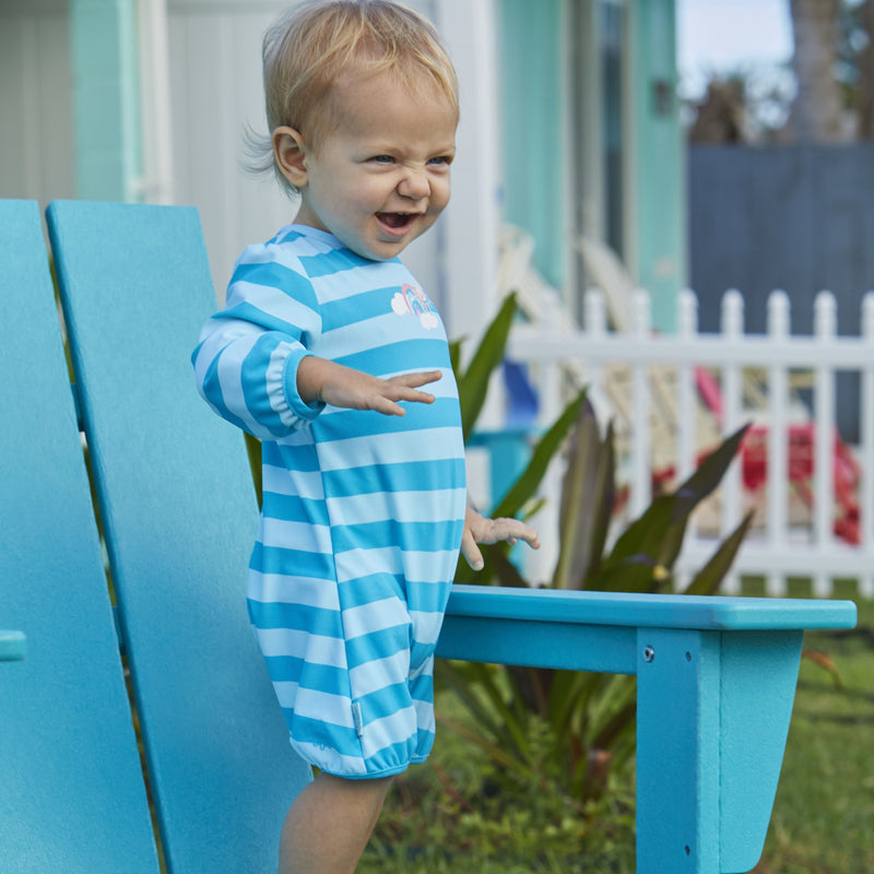 Little baby wearing UV Skinz's baby girl's one-piece swimsuit in aquamarine sun stripe|aquamarine-sun-stripe