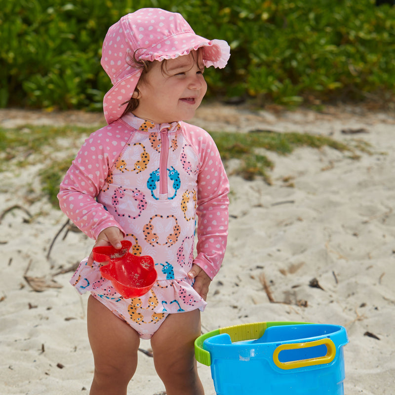 Baby girl in UV Skinz's baby girls swim flap hat in pink spots|pink-spots