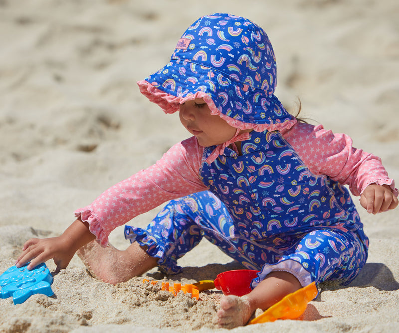 Little Girl Playing in the Sand in the Baby Girl's Reversible Sun Hat in Rainbow Stars|rainbow-stars