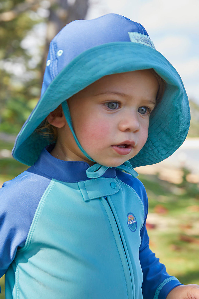 Baby boy in a sun hat on the beach|tropical-cascade