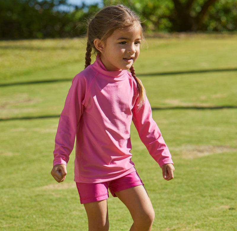 Little girl in UV Skinz's girl's swim shorts in hot pink|hot-pink