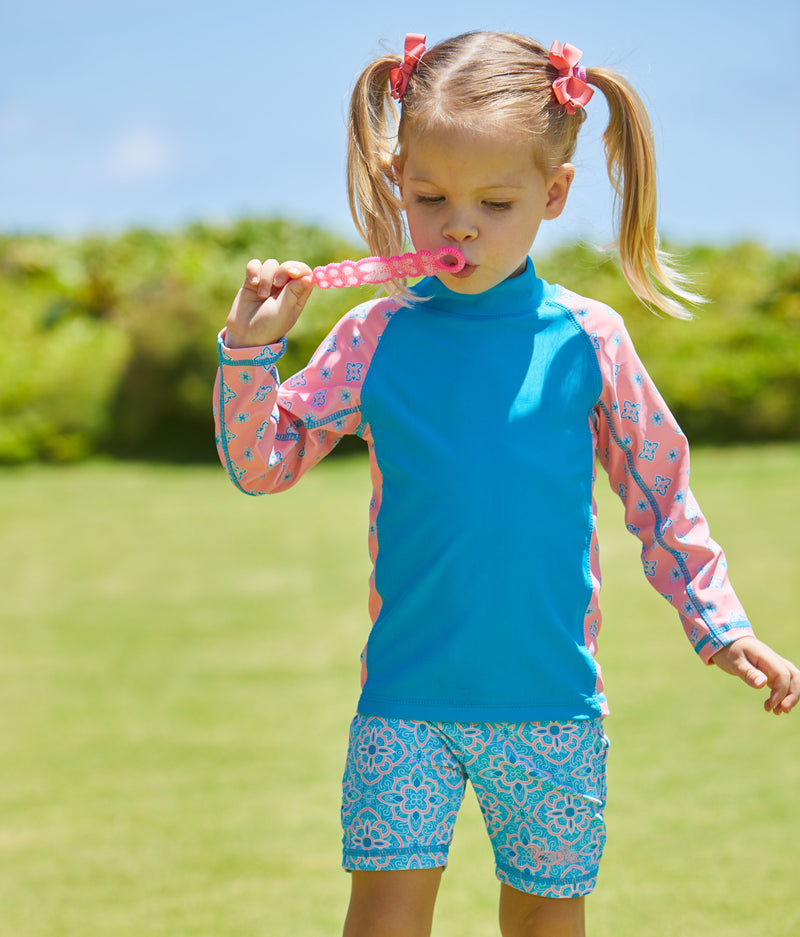 Little girl blowing bubbles in the girl's long sleeve UPF swim shirt in hawaiian ocean mini medallion|hawaiian-ocean-mini-medallion