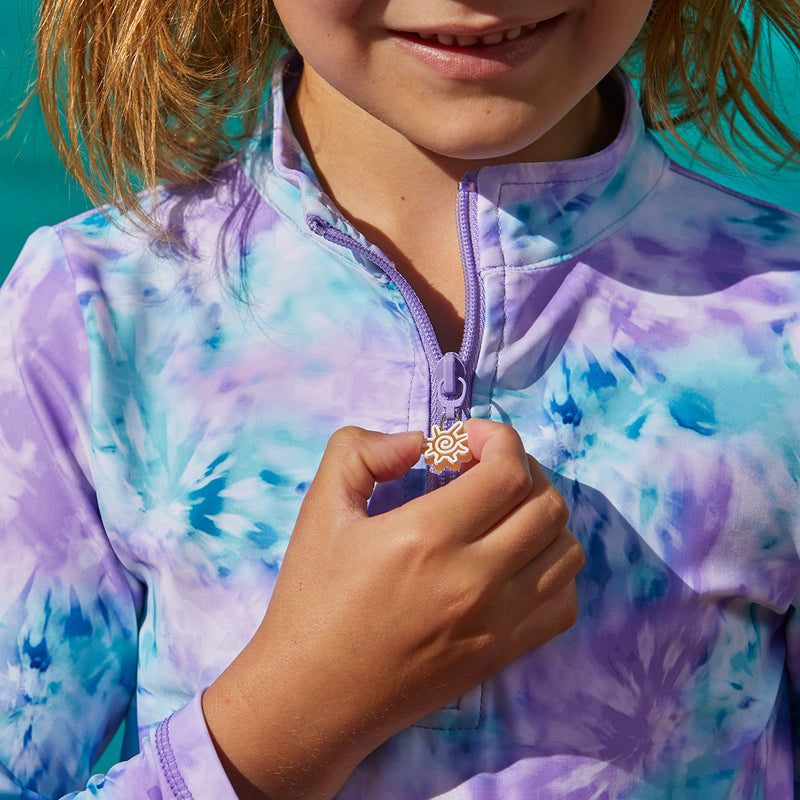 Close up of the zipper on UV Skinz's girl’s half zipped ruched swim shirt in lilac tie dye|lilac-tie-dye