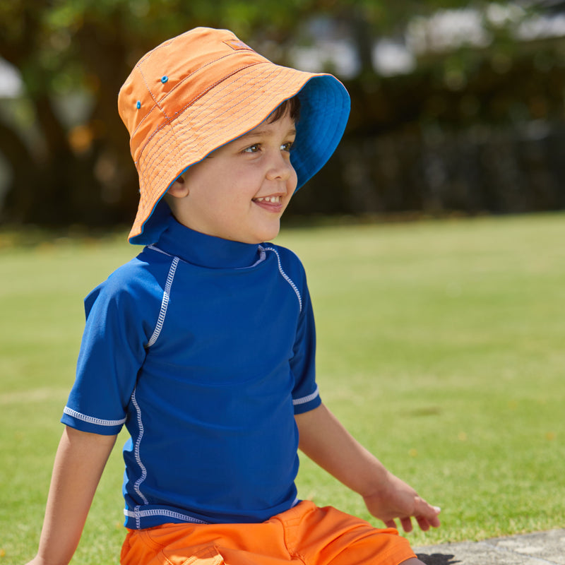 Boy wearing the boy's bucket hat in royal orange|royal-orange