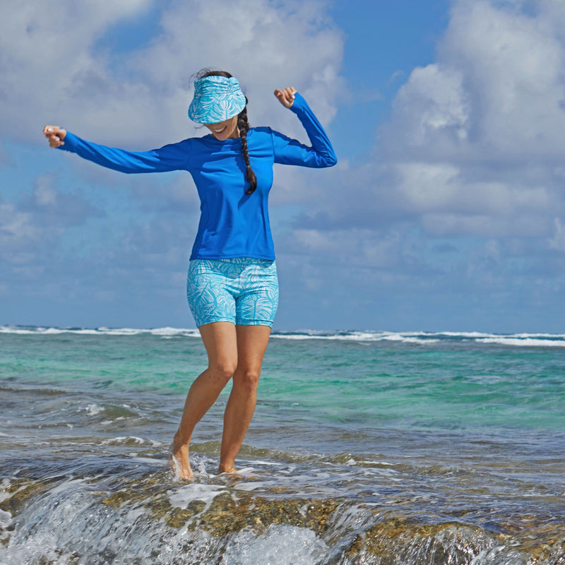 Woman in UV Skinz's women's long sleeve crew swim shirt in deep sea|deep-sea