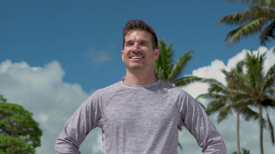 Man on the beach in UV Skinz's men's long sleeve crew swim shirt 