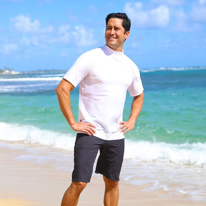 Man walking on the beach in UV Skinz's men's coastal board shorts in black|black