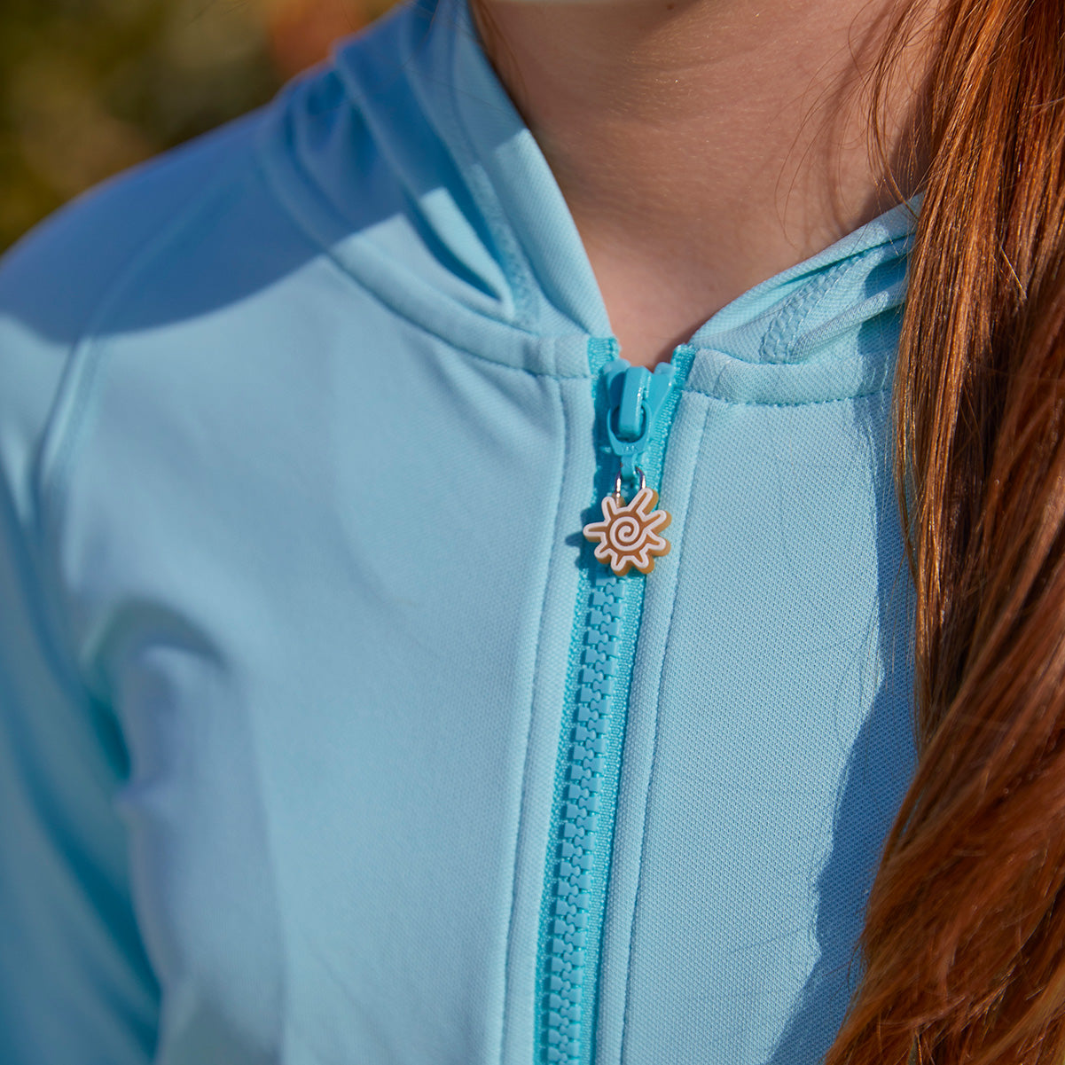 Close up of the zipper on UV Skinz's Girl's Zip-Up Hoodie|glacier