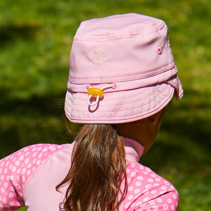 back view of the kid's adjustable flap sun hat in light pink|light-pink