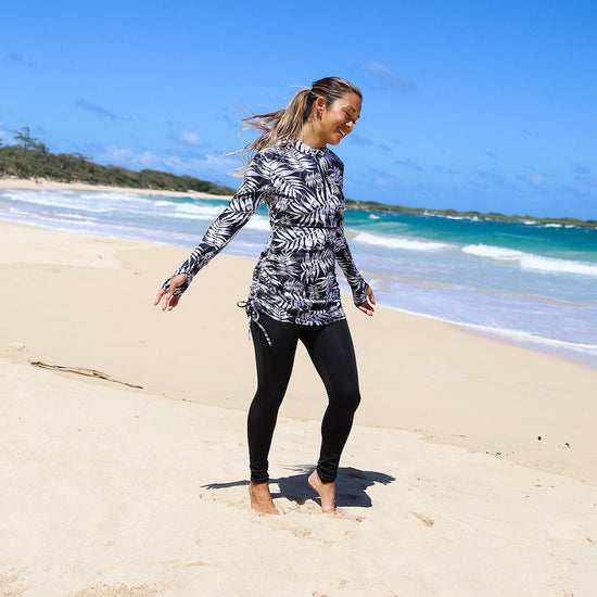 woman in UV Skinz's convertible swim/shirt dress on the beach|black-palms