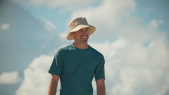 Man Walking Down the Beach in UV Skinz's Men's Bucket Hat