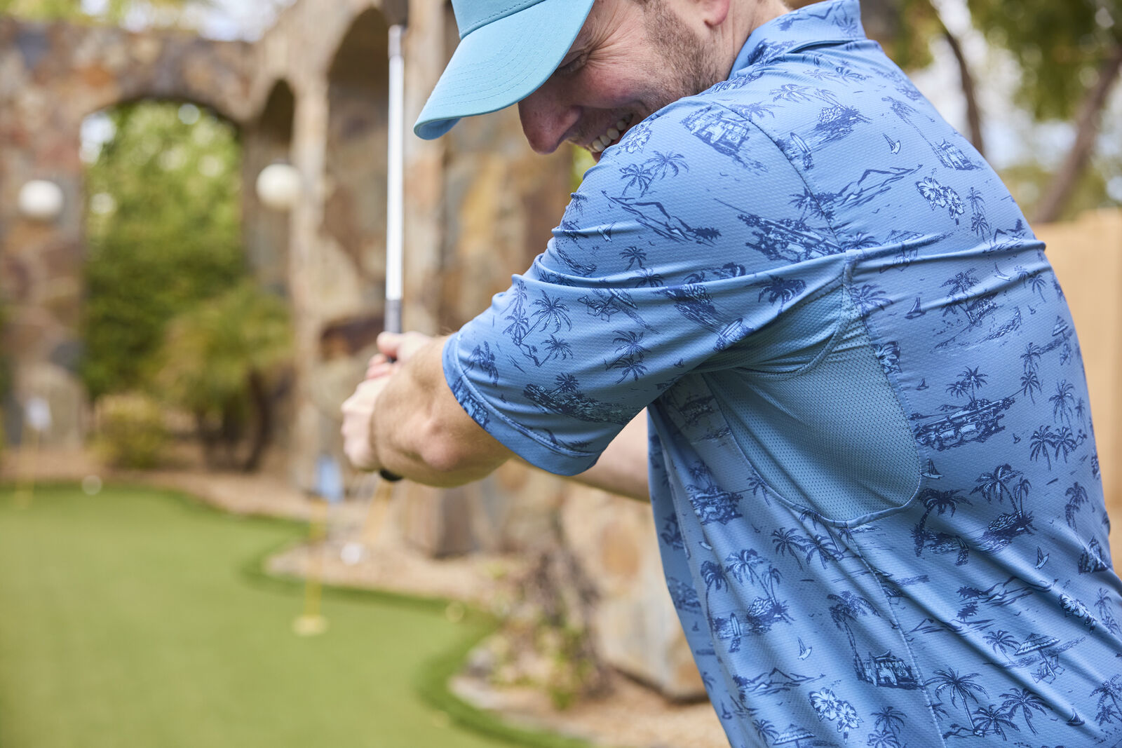 Close-up of a golfer at a resort wearing UV Skinz performance polo and GOLO snapback hat, demonstrating effective sun protection on the course