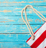 Red and white beach bag on a picnic table