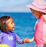 babies playing in the sun with UPF swimwear on