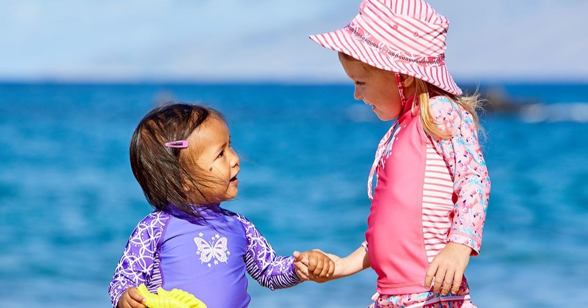babies playing in the sun with UPF swimwear on