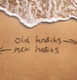 old habits and new habits written in sand