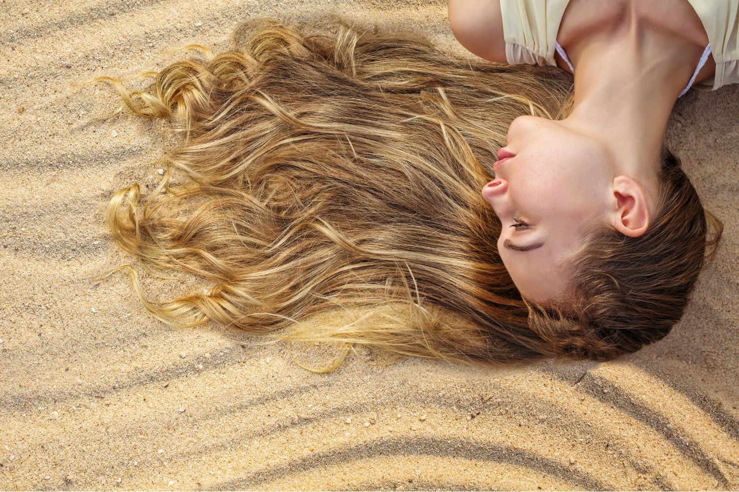 Woman laying out in the sun exposing her hair to harmful UV rays