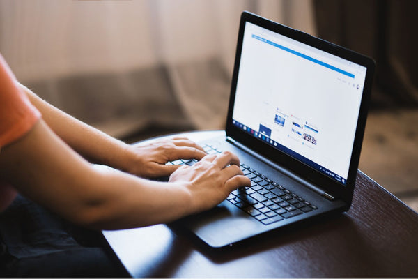 woman typing on a lap top indoors