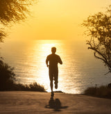 Man running in UPF 50+ clothing towards the ocean