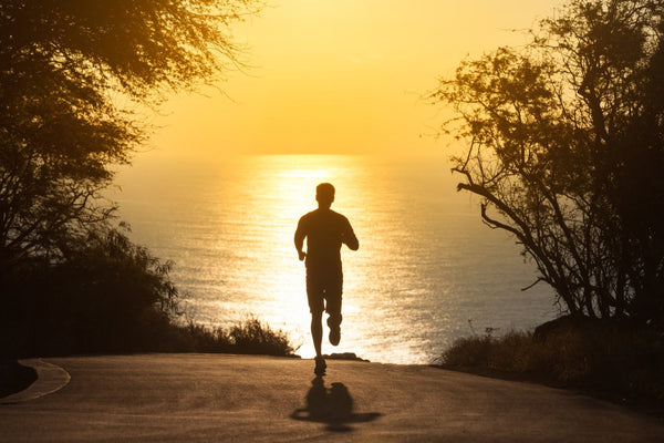 Man running in UPF 50+ clothing towards the ocean