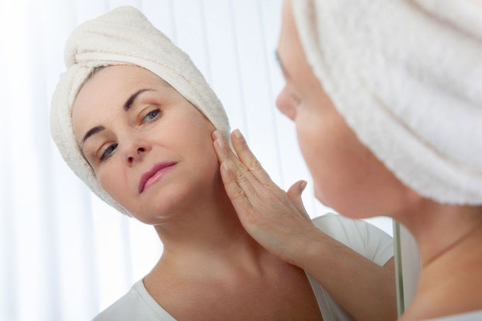 Woman looking at her wrinkles caused by UVA exposure