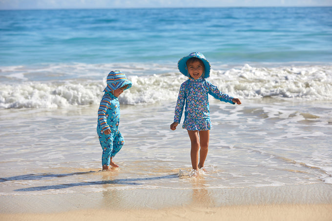 Babies in their baby UPF clothing at the beach