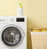 A washing machine next to a hamper of dirty UPF clothing