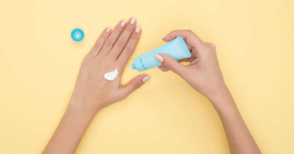 woman putting sunscreen on her hand