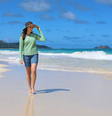 Woman on the beach in a UV Skinz's rash guard