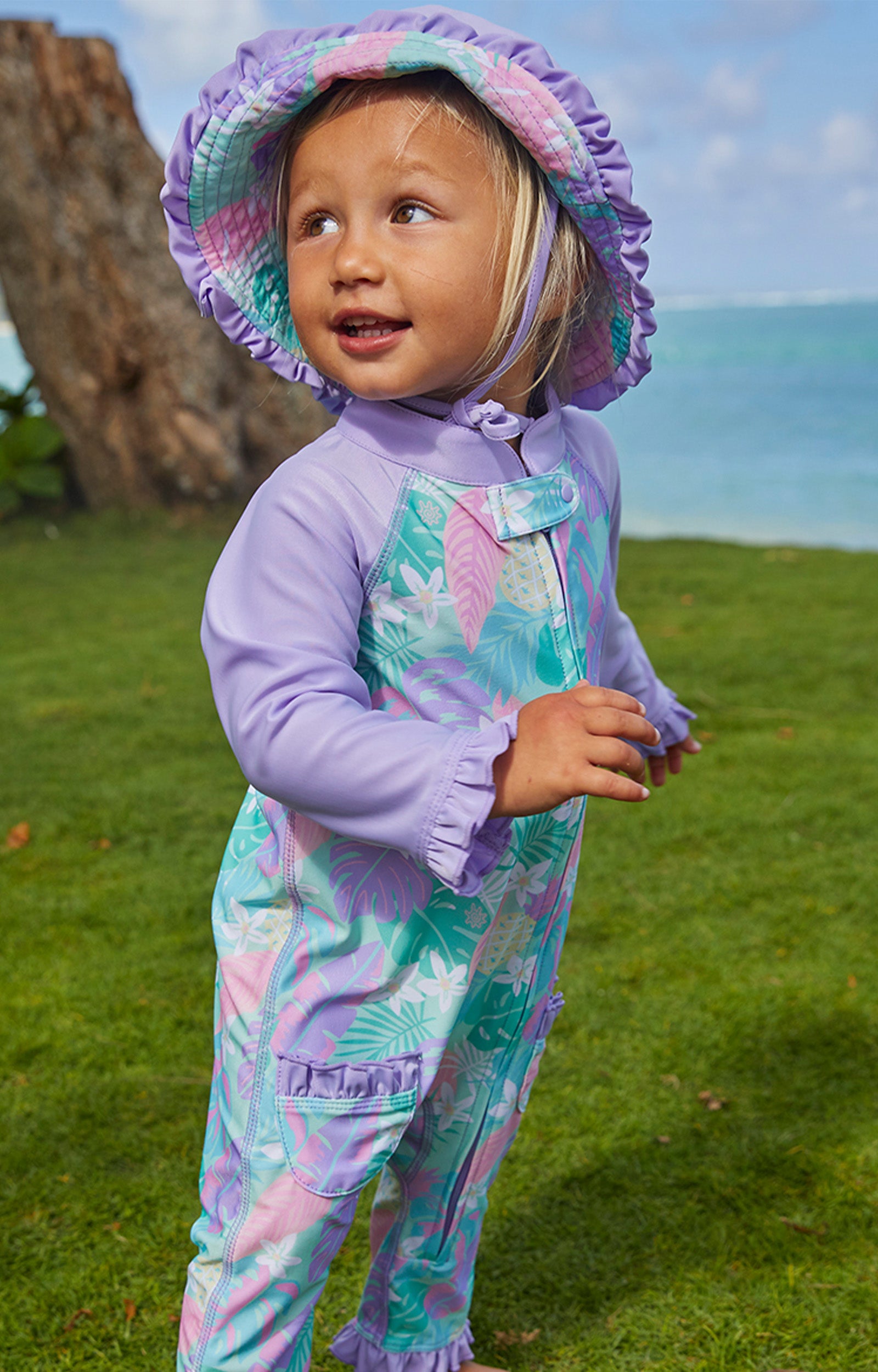 Little baby girl in UV Skinz's baby girls long-sleeve swimsuit|tie-dye-splash