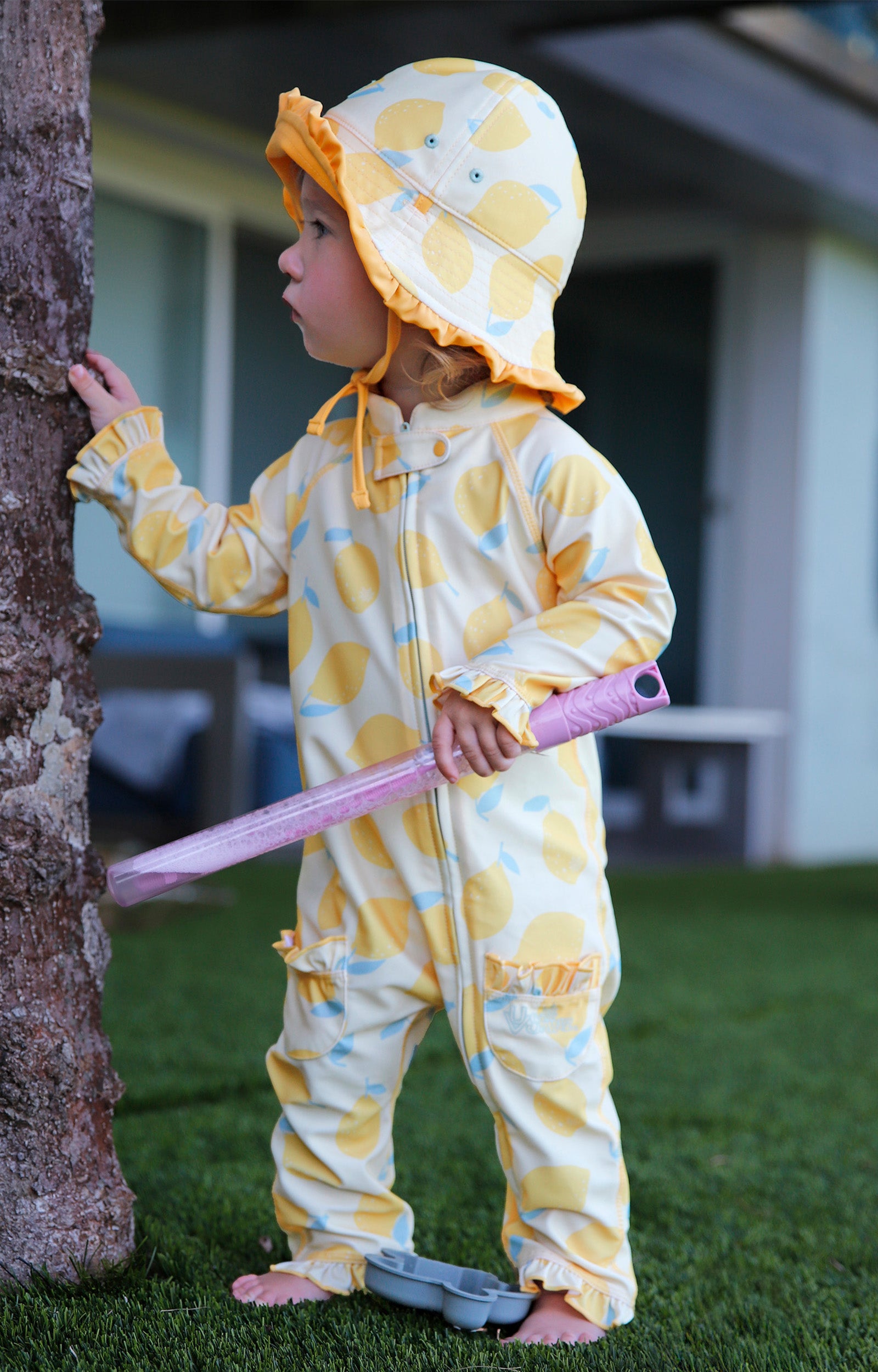 baby girl in grass in sun & swim suit in lemonade stand|lemonade-stand