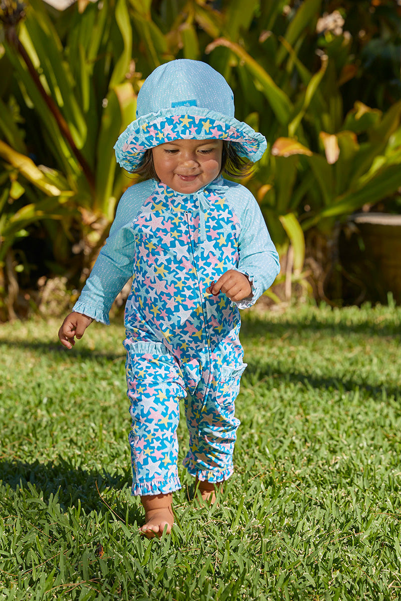 Little baby girl in UV Skinz's baby girls long-sleeve swimsuit in starfish party|starfish-party