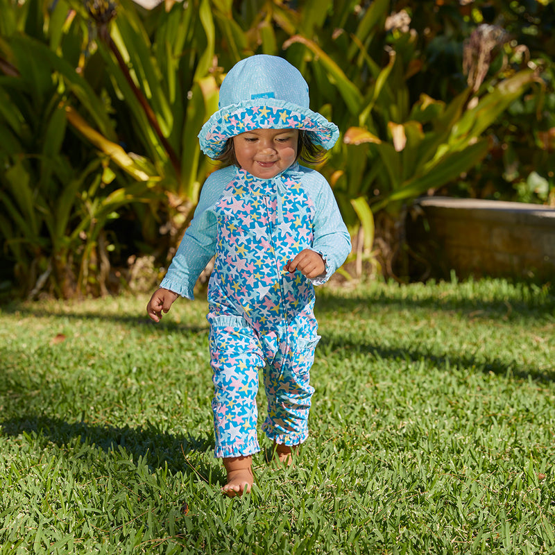 Little baby girl in UV Skinz's baby girls long-sleeve swimsuit in starfish party|starfish-party