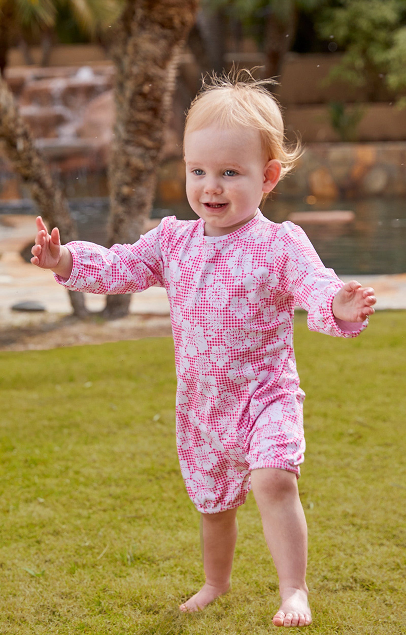 Little baby girl in UV Skinz's UPF 50+ one-piece swimsuit|pink-hibiscus-gingham