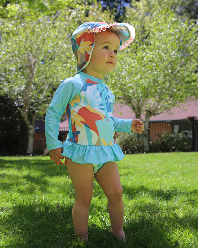 baby girl in long sleeve ruffled swim suit in beach picasso|beach-picasso