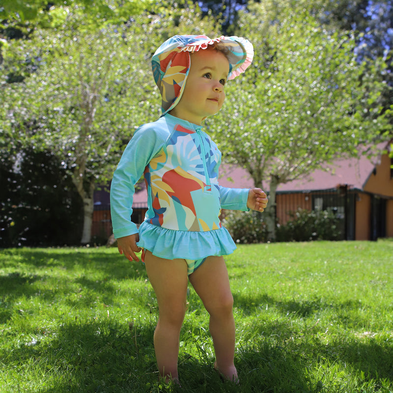 baby girl in long sleeve ruffled swim suit in beach picasso|beach-picasso