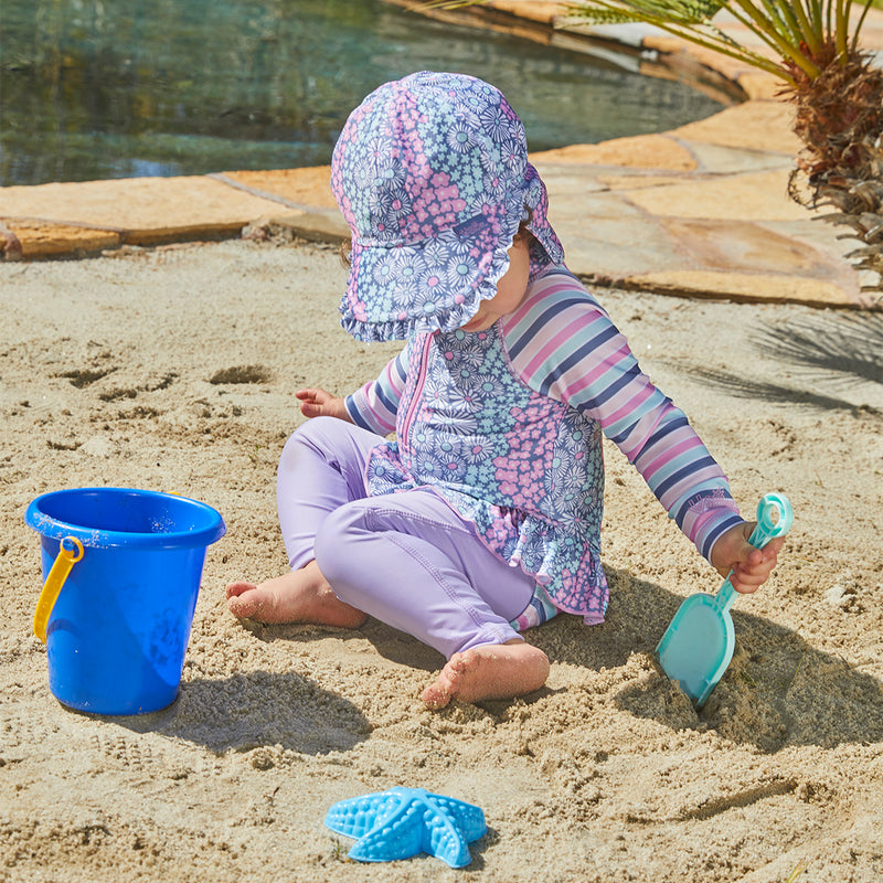 Baby girl playing in UV Skinz's baby girl's swim flap hat|daisy-field