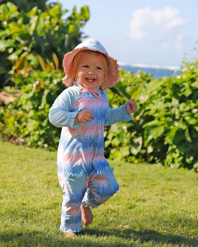 baby girl running in grass in reversible swim hat in aquamarine dusty pink|aquamarine-dusty-pink